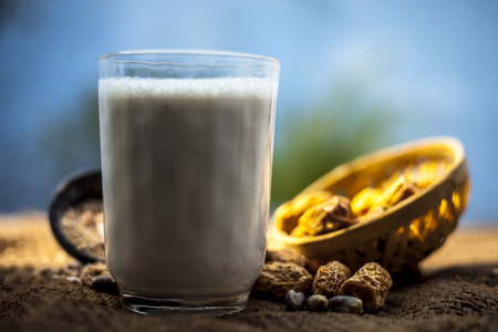 Close up of popular Indian and asian Winter drink on brown colroed gunny bag's surface i.e. Kharek ka dudh or dried dates milk consisting of milk,dried dates,cashews,almonds dry fruits and sugar.の写真素材