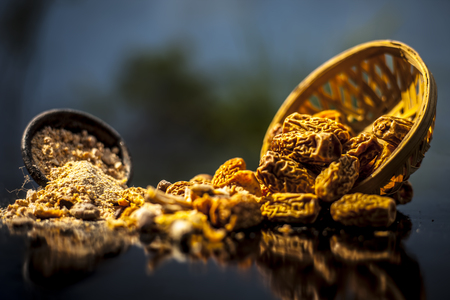 Close up of Dried dates or kharek or sukhi khajoor in a hamper with its powder on wooden surface.の写真素材