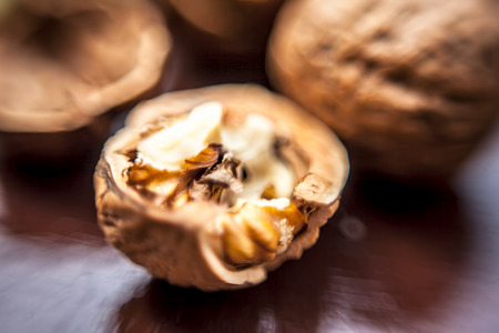 Macro shot of raw organic walnuts in sell on wooden surface.