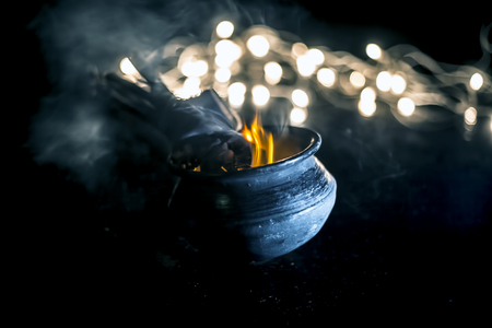 Popular and famous ancient method to kill mosquitoes or mosquito repellent. i.e. Burning some sticks of certain trees in a pot.Close up shot with blurred background of lights.の写真素材