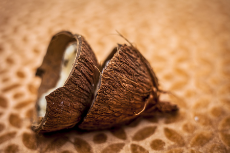 Raw dried organic cut coconut on brown colored surface,close up shot.