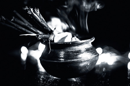 Popular and famous ancient method to kill mosquitoes or mosquito repellent. i.e. Burning some sticks of certain trees in a pot.Close up shot with blurred background of lights.の写真素材