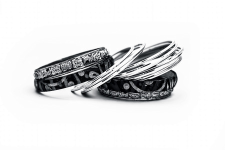 Close up of luxurious silver and gold bangles with diamonds on it isolated on white.