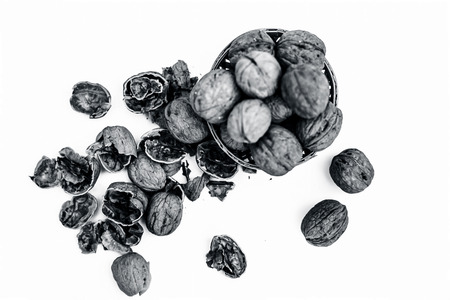 Close up of raw organic Walnut or Juglans or Akhrot or Akharot isolated on white in a hamper without shell on surface.の写真素材