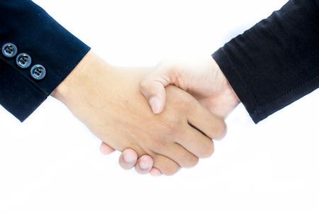 Close up of hands of two different business mans isolated on white shaking hands concept of dealing.の写真素材