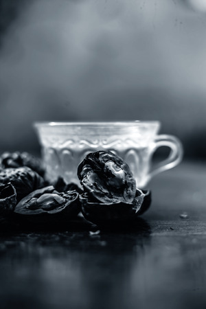 Close up of herbal organic tea of wall nut or walnut tea in a transparent glass cup with raw wall nut in shell and broken also.の写真素材