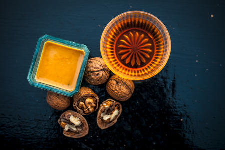 Close up of best home remedy to treat Anemia in a glass bowl on wooden surface consisting of walnut powder and raw organic honey.の写真素材