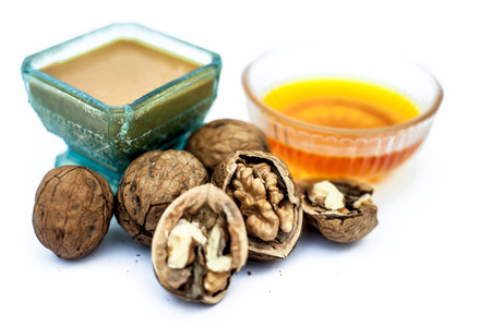 Close up of best home remedy to treat Anemia in a glass bowl isolated on white consisting of walnut powder and raw organic honey.の写真素材