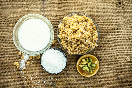 Close up of popular Indian & Asian sweet dish i.e. Malida or churma na ladu or moti chur na ladu in a bowl on brown surface with entire ingredeints including dry fruits.;の写真素材