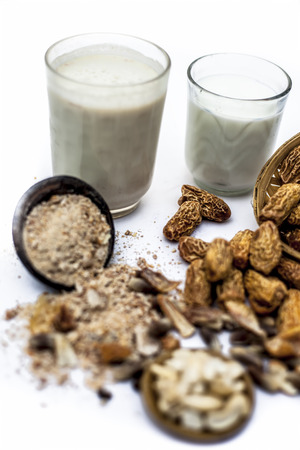Close up of popular Indian and asian Winter drink isolated on white i.e. Kharek ka dudh or dried dates milk consisting of milk,dried dates,cashews,almonds dry fruits and sugar.の写真素材