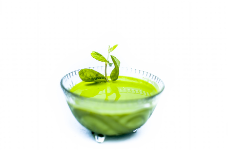 Close up shot of popular Indian sauce or chutney i.e. Phudina ki chutney isolated on white in a transparent glass bowl.の写真素材