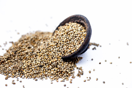 Close up of grains of pearl millet or bajra or Pennisetum glaucum in a clay bowl isolated on white.の写真素材