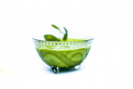 Close up shot of popular Indian sauce or chutney i.e. Phudina ki chutney isolated on white in a transparent glass bowl.の写真素材
