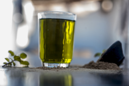 Ayurvedic herb brahmi or Waterhyssop with its herbal and beneficial extract  in a transparent glass along with its powder on wooden surface.の写真素材
