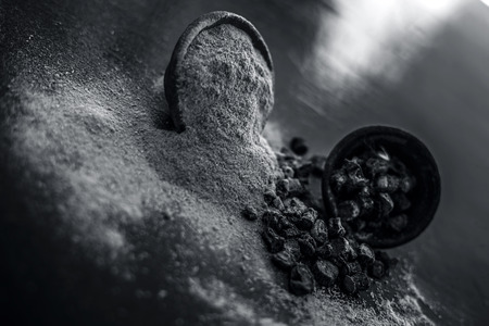 Popular Indian & Asian ayurvedic organic herb musli or Chlorophytum borivilianum or Curculigo orchioides or kali moosli in a clay with its powder in another bowl on wooden surface.の写真素材
