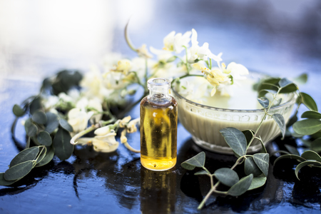 Herbal and floral essence or concentration made from Moringa concanensis Nimmo also known as Kadvo Saragvo, Konkan Moringa in a glass bottle on wooden surface.の写真素材