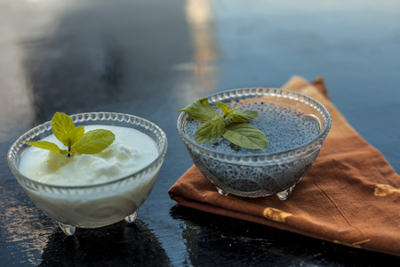 Best and most effective method to reduce weight i.e. Soaked sweet basil seeds well mixed in curd or yogurt.Entire raw ingredients on wooden surface.の写真素材