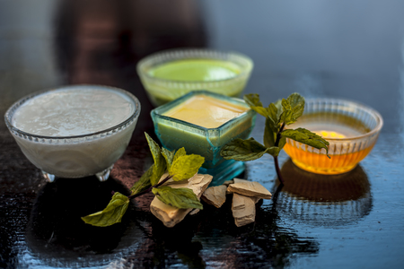 Best face pack or ubtan to remove excess oil from skin on wooden surface consisting of mentha leaves or mint leaves along with fuller's earth or bleaching clay and curd with honey.の写真素材