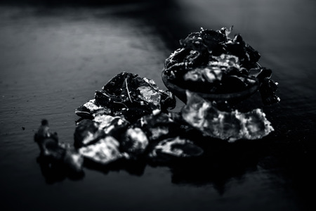 Raw peeled tamarind or imli in a clay bowl on wooden surface.の写真素材