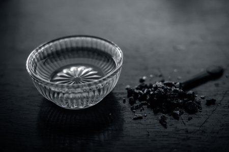 Close up of raw honey in a glass bowl on wooden surface along with powdered rock slat in a black colored spoon.Helps in getting good possible sleep.の写真素材