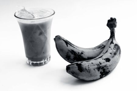 Raw organic fresh banana and its smoothie or shake or banana milk in a glass isolated on white.の写真素材