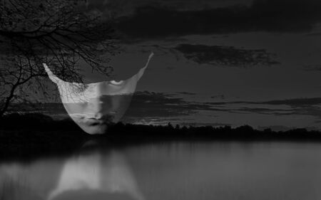 Double exposure portrait of young male fashion model with sunset image of lake.の写真素材