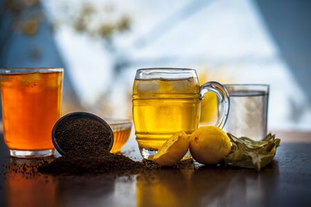 Herbal detoxifying aloe vera iced tea in a big transparent glass with entire ingredients which are...