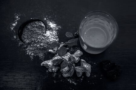 Home remedy to reduce headache or to treat headache on wooden surface i.e. Hing or Devil's dung powder well mixed in water.の写真素材