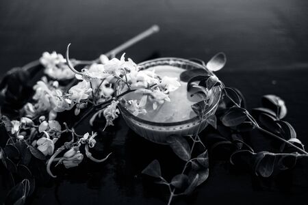 Ayurvedic herb Drumstick flowers along with some leaves on wooden surface along with its paste in a glass bowl.の写真素材