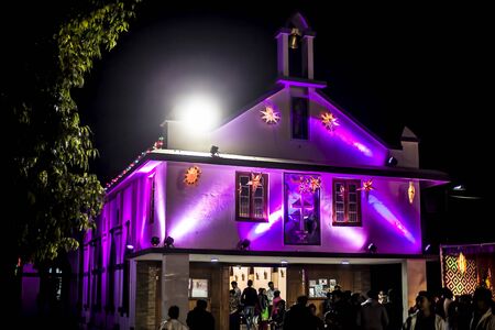 Church decorated with colorful lights during Christmas and a Christmas tree.の写真素材
