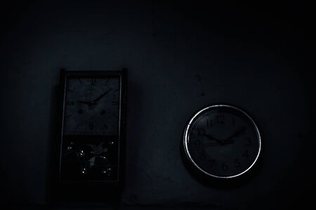 Two different clocks on the wall which are antique and simple common modern wall clock isolated.の写真素材