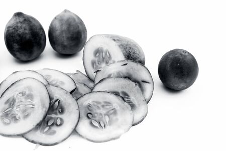 Cucumber face pack isolated on white i.e. Cucumber slices or cucumber pulp well mixed with turmeric powder and some lemon juice in a bowl and entire raw ingredients present on the surface.の写真素材