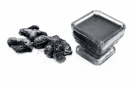 Raw dried ginger and its paste or tincture in a glass bowl isolated on white.の写真素材