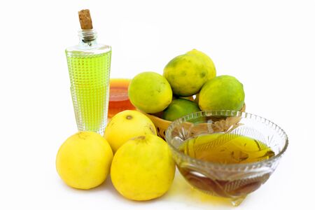 Lemon hair growth mask isolated on white i.e. Lemon juice well mixed with honey and Olive oil in a glass bowl with entire raw ingredients.の写真素材