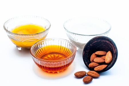 Natural ex-foliating face mask isolated on white in a glass bowl i.e. raw milk well mixed with honey, & almonds.Entire raw ingredients present on the surface.の写真素材