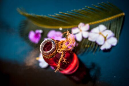 Rosemary concentration or essence in a glass bottle on wooden surface along with its flowers and...