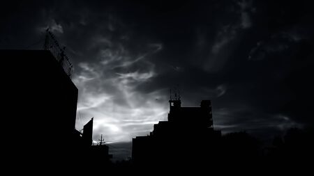 Sunset Dusk time shot of clouds and sun setting in background along with some silhouette of buildings also.の写真素材