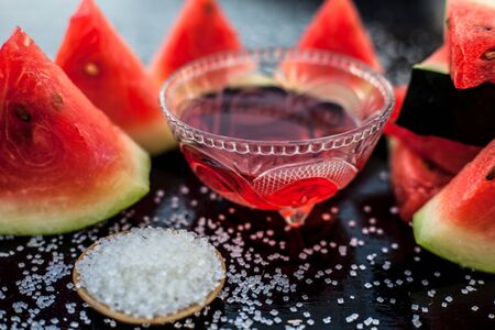 Best recipe ingredient to make homemade sugar scrub on wooden surface consisting of watermelon pulp well mixed with sugar in a glass bowl.の写真素材