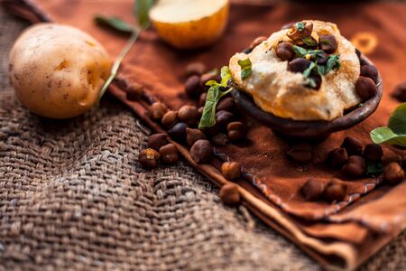 Famous Indian & Asian street food dish i.e. Panipuri snack in a clay bowl along with its flavored spicy water in another clay vessel. Entire consisting raw ingredients present on the surface.の写真素材