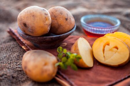 Potato juice's face pack or face mask in a glass bowl on jute bag's surface consisting of potato juice and honey.Used for skin whitening purpose along with entire ingredients.Horizontal low angle.の写真素材