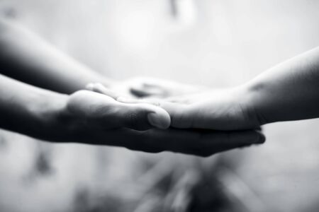 Child hand comparing her hand with her father shot with blurred bokeh background and the concept of Fatherâs day ( 16th June).の写真素材