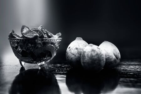 Raw cut aloevera or aloe vera gel in a glass bowl and some fresh ripe lemons or limbu or nimbo on...