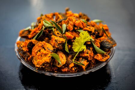 Famous Indian & Gujarati snack dish in a glass plate on wooden surface i.e. Patra or paatra consisting of mainly Colocasia esculenta or arbi ke pan or elephant ear leaves and spices.の写真素材