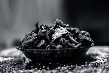 Famous Indian & Gujarati snack dish in a glass plate on wooden surface i.e. Patra or paatra consisting of mainly Colocasia esculenta or arbi ke pan or elephant ear leaves and spices. Horizontal shot.の写真素材