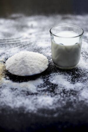Face mask for flawless skin on wooden surface consisting of rice flour,corn flour,honey,milk, in a glass bowl and entire raw ingredients present on the surface.の写真素材