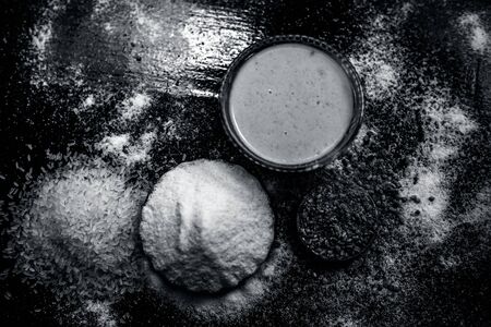 Hair growth remedy of rice flour water and fenugreek/coriander/parsley seeds powder on wooden surface and its paste in a glass bowl with some rice flour spread on the surface. Horizontal shot.の写真素材