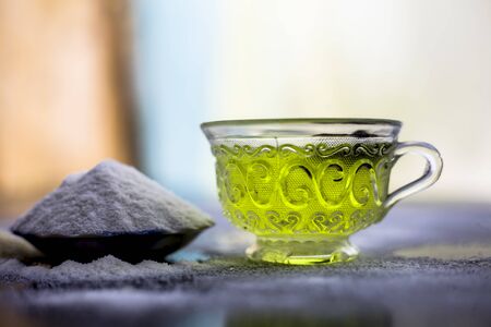 Rice flour and rice grain on wooden surface along with some green tea in a transparent glass cup and a star anise in it.Face mask for the treatment for smoother skin.の写真素材