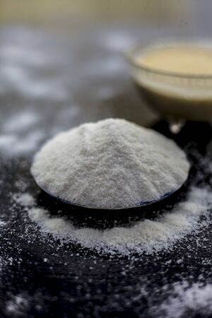 Rice flour and rice grain on wooden surface along with some green tea in a transparent glass cup and a star anise in it.Face mask for the treatment for smoother skin.の写真素材