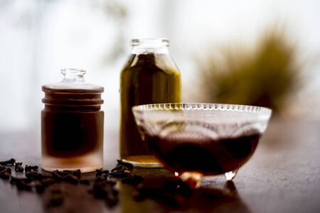 Face mask of clove oil on wooden surface consisting of clove oil and olive oil for the treatment of cleaning dirt and black heads from the skin.の写真素材