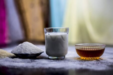 Face mask for flawless skin on wooden surface consisting of rice flour,corn flour,honey,milk, in a...